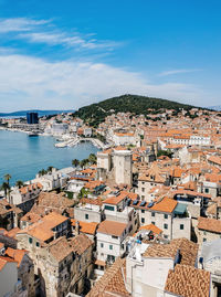 High angle view of townscape by sea against sky