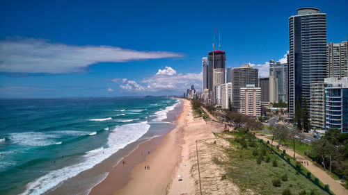 Panoramic view of beach and buildings against blue sky