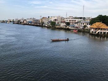 River amidst buildings in city against sky