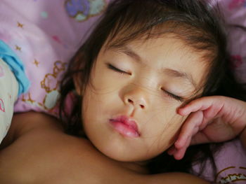 Close-up of cute baby sleeping on bed