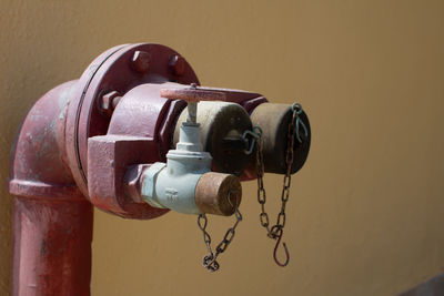 Close-up of fire hydrant against wall