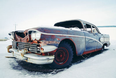 Close-up of car on snow against clear sky