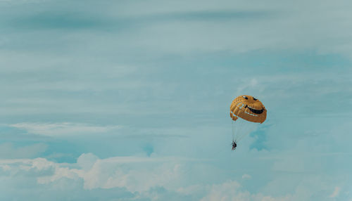 Low angle view of person paragliding against sky