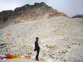 Side view of man standing against mountain