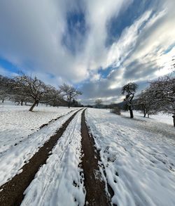 Snow covered land against sky during winter