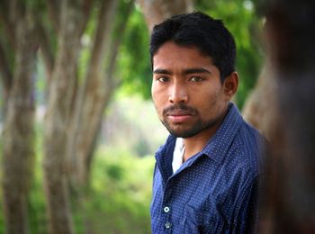 Portrait of young man standing in forest