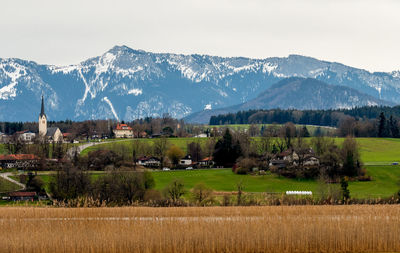 Scenic view of field by mountains against sky
