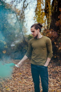 Young man looking away in forest