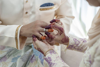 Midsection of couple holding hands