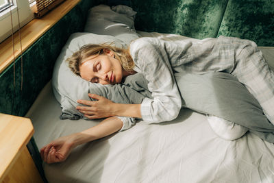 High angle view of woman sitting on bed at home