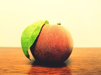 Close-up of apple on table against white background