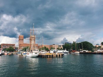 Boats in city against sky