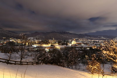 Illuminated cityscape against sky during winter