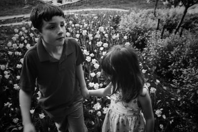 Siblings standing on field