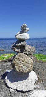 Stack of pebbles on beach against clear sky