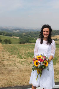 Portrait of a smiling woman standing on field