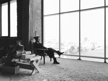 Young woman sitting on window