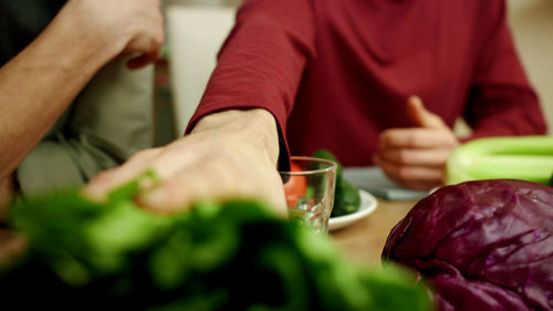 Midsection of man holding ice cream on table