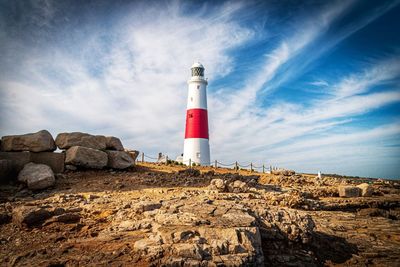 Lighthouse by sea against sky