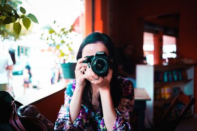 Portrait of young woman photographing