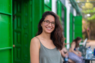 Portrait of young woman standing against wall