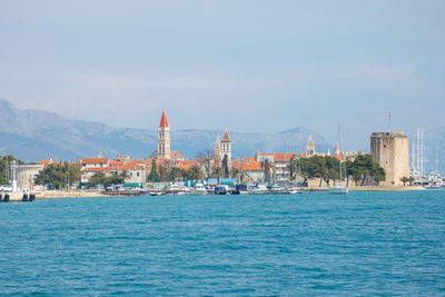 View of sea by buildings against sky