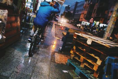 Low section of man standing on illuminated street at night