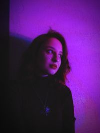 Portrait of young woman looking away at night