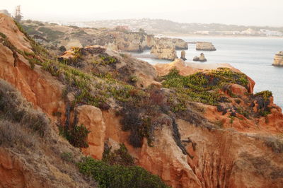 Scenic view of cliff by sea against sky