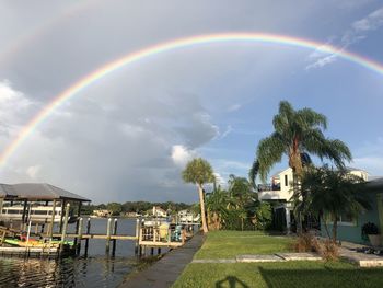 Scenic view of rainbow over building and trees against sky