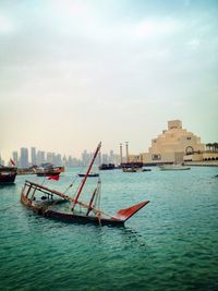 Sinking boat in sea against sky