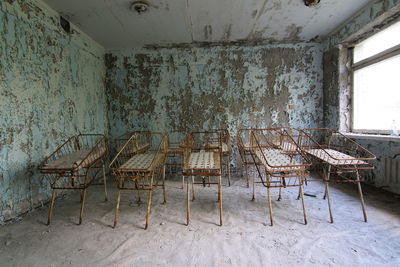 Old cribs against wall in abandoned hospital