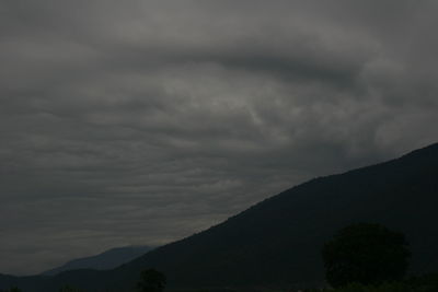 Silhouette of mountain against cloudy sky