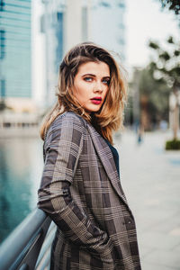 Portrait of woman standing against water