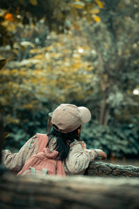 Rear view of woman sitting on rock