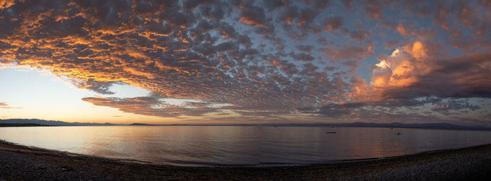 Scenic view of sea against dramatic sky during sunset