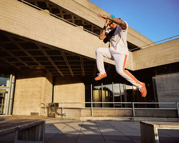 Man jumping against building