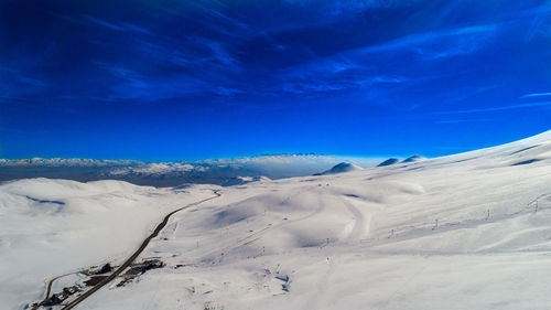 Snow covered mountain against blue sky