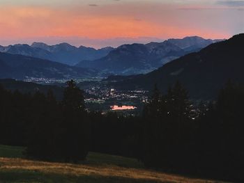 Silhouette trees and mountains against sky at sunset