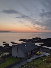 High angle view of houses and sea against sky during sunset