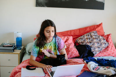 Young woman using mobile phone at home