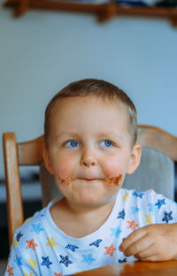 Little cute boy eating bread with chocolate butter