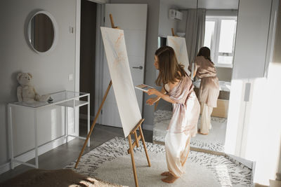 Portrait of young woman standing at home