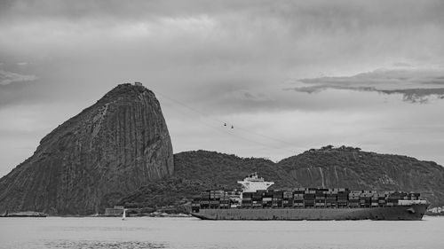 Photo of sugarloaf mountain with a cargo ship passing in front of it in guanabara bay