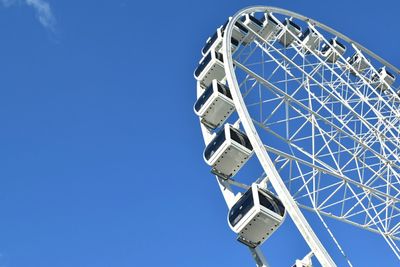 Low angle view of ferris wheel against blue sky