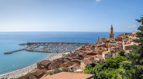 High angle view of buildings by sea against clear sky