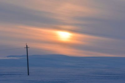 Electricity pylon against sky during sunset