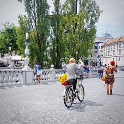 People on bicycle against sky in city