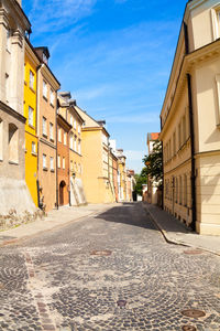 Empty road amidst buildings in town