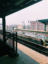 Railroad tracks in city against clear sky